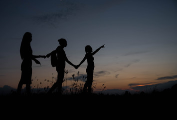 Fototapeta na wymiar Friends holding hands at sunset.