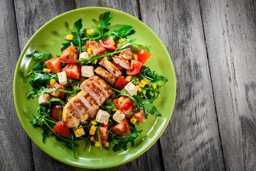 Fresh salad with chicken breast, arugula and tomato