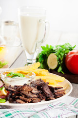 Grilled meat with French fries and fresh vegetables