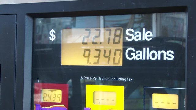 4K video at gas station pump filling up, close up on price per gallon as fuel pumps.