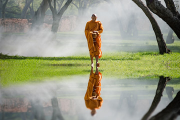 Fototapeta premium Buddhist monk walk receive food in the morning, among cold weather and fog, Vintage