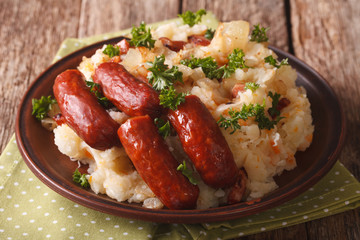 Dutch stamppot - a mashed potatoes, sauerkraut and carrots, with sausages close-up. horizontal

