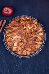 Homemade apple cake on a black wooden abckground