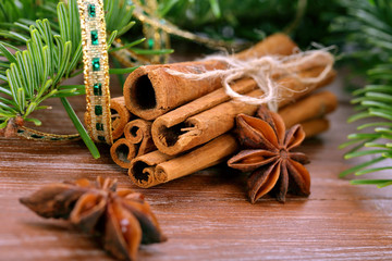 Cinnamon sticks and anise stars with decoration on wooden backgr