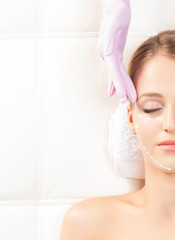 Naklejka premium Young woman on a facial medical procedure
