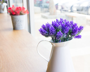 Decoration artificial flower in pot on wood table