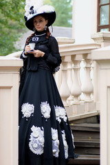 Fototapeta na wymiar woman in vintage dress on porch of castle