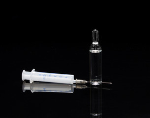  Medical ampoule and syringe on a black background with reflecti