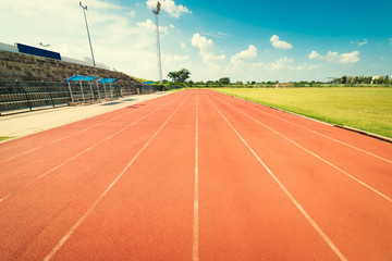 Red running track in stadium. Running track on blue sky.