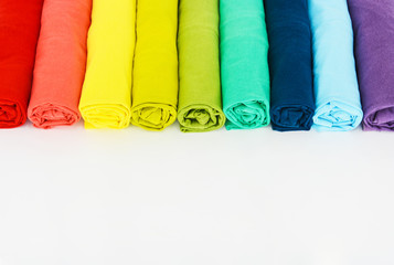 stack of colorful t-shirt rolled up on white background, copy space