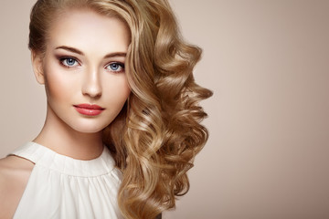 Naklejka premium Fashion portrait of young beautiful woman with jewelry and elegant hairstyle. Blonde girl with long wavy hair. Perfect make-up. Beauty style woman with diamond accessories