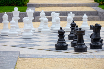 Detail of whites and blacks pieces of an outdoor chess