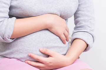 Pregnant woman has stomachache and touching her belly