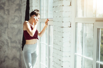 Slim girl talking on a cellphone after training