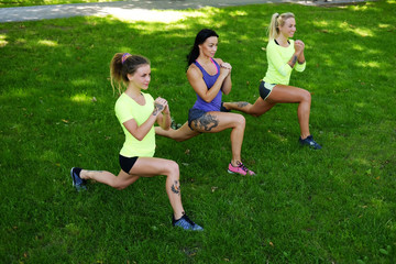 Sporty females warming up in a park.