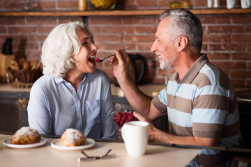 Elderly man feeding his lovely wife