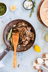 Fried mushrooms cast-iron pan on table.
