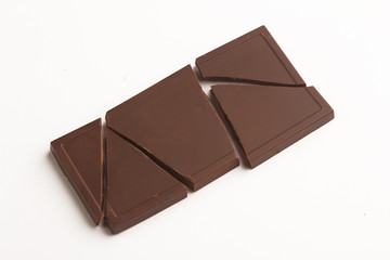 Broken dark chocolate bar on white background
