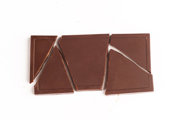 Broken dark chocolate bar on white background