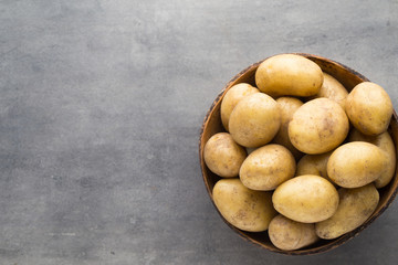 New potato on the bowl, gray background.