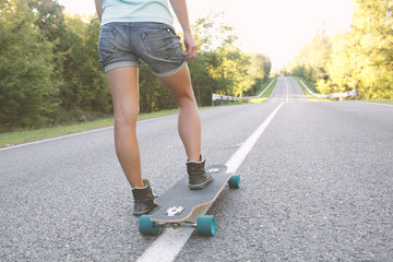 Teenage Girl ready to ride on a longboard.