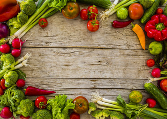 Frame from fresh and ripe vegetables on wooden background. Healthy vegetarian food with space for text. 