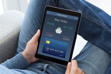 man in jeans holding tablet computer with online ship ticket