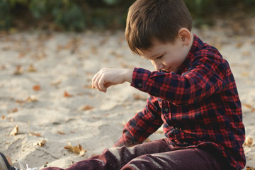 Boy strewing sand outdoor