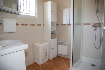 Modern bathroom with white ceramic appliances and shower cabin