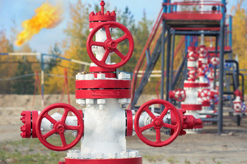 Control valves in the oil field with torch in the background