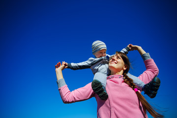 Mother with the son against the blue sky