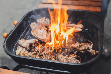 Grill steaks on metal grate with flame, barbecue