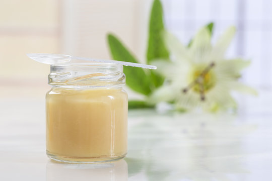 raw organic royal jelly in a small bottle with passion flower