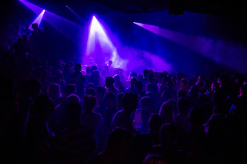 Fototapeta na wymiar Purple lights in a crowded club