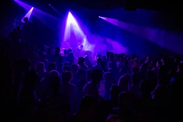 Fotobehang Purple lights in a crowded club © hennyvanroomen
