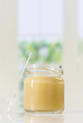 raw organic royal jelly in a small bottle with spoon
