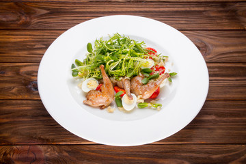 Plate with whole baked quails in a rustic wooden setting