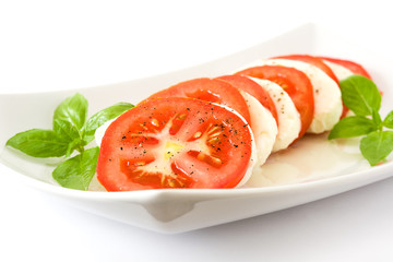 Caprese salad with mozzarella cheese, tomatoes and basil isolated on white background

