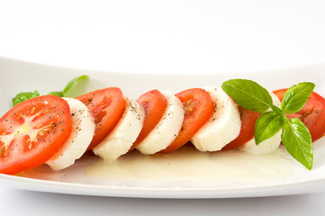 Caprese salad with mozzarella cheese, tomatoes and basil isolated on white background

