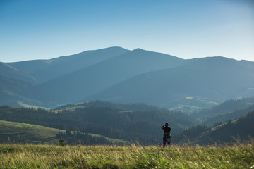 Fototapeta na wymiar Photographer shoots a mountain landscape