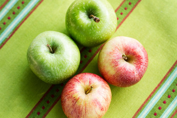 Manzanas verdes y rojas sobre una paño de cocina. Vista superior