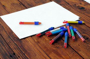 Obraz premium Blank paper and colorful pencils on the wooden table.