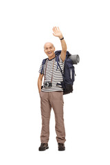 Mature male hiker waving at the camera