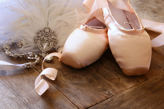 Image of silk pointe shoes and tutu on wooden floor