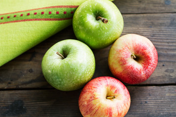 Manzanas rojas y verdes sobre una mesa de madera rústica. Vista superior