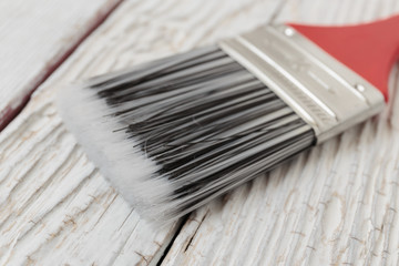 Paint brush on a white wooden board