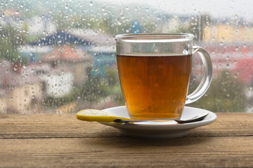cup of coffee espresso on wooden table next to window.