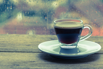 cup of coffee espresso on wooden table next to window