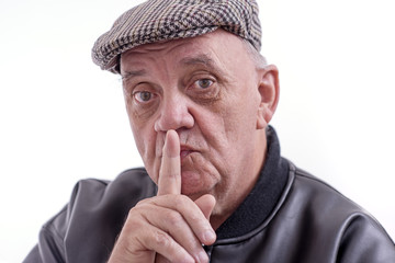 homme sénior faisant signe de silence avec la main