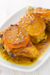 fried chicken with orange on white dish on wooden background